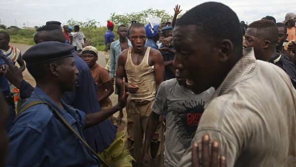 Manifestantes protestam de policial acusada de atirar em uma pessoa no bairro de Buterere, em Bujumbura, Burundi - Sputnik Brasil
