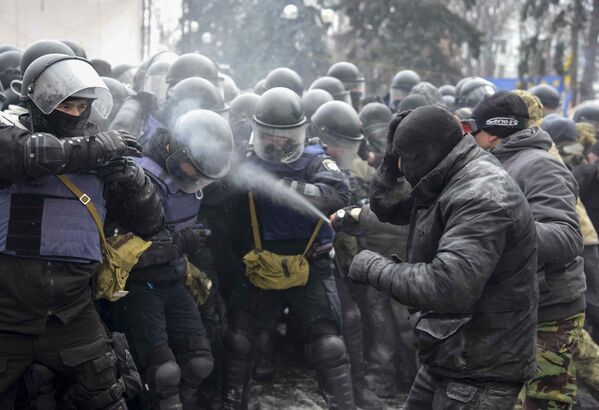 Homem lança gás lacrimogêneo contra um policial no campo dos apoiantes de Mikheil Saakashvilli perto do parlamento em Kiev - Sputnik Brasil