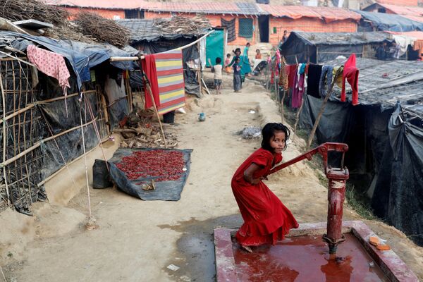 Menina refugiada rohingya tira água com uma bomba hidráulica no campo de Palong Khali, no Bangladesh - Sputnik Brasil