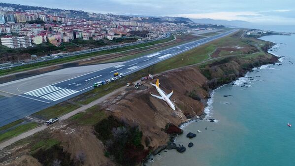 Avião das linhas aéreas turcas Pegasus Airlines fica pendurado no declive na costa do mar Negro após acidente durante a aterrisagem, na Turquia - Sputnik Brasil