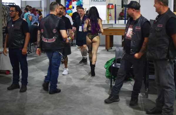 Mulher passa por motoqueiros durante o festival anual Tattoo Week 2018 no Rio de Janeiro - Sputnik Brasil