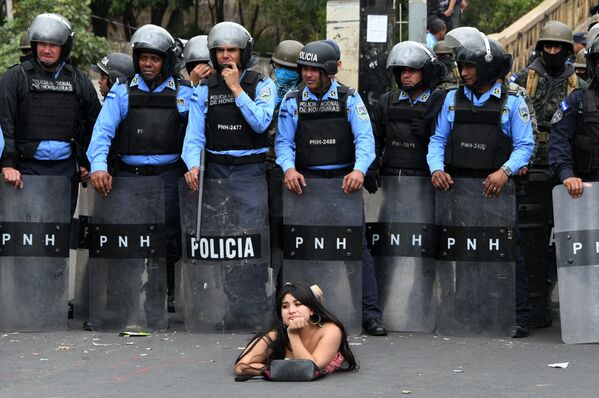 Apoiante do candidato de oposição à presidência hondurenha, Salvador Nasralla, entre policiais durante uma manifestação contra a reeleição do presidente Juan Orlando Hernandez - Sputnik Brasil