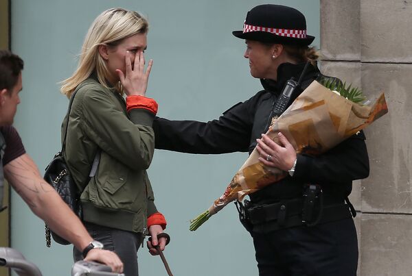Uma agente da polícia consola uma moça que veio depositar flores na ponte de Londres, em memória às vítimas do ataque terrorista de 3 de junho de 2017 - Sputnik Brasil