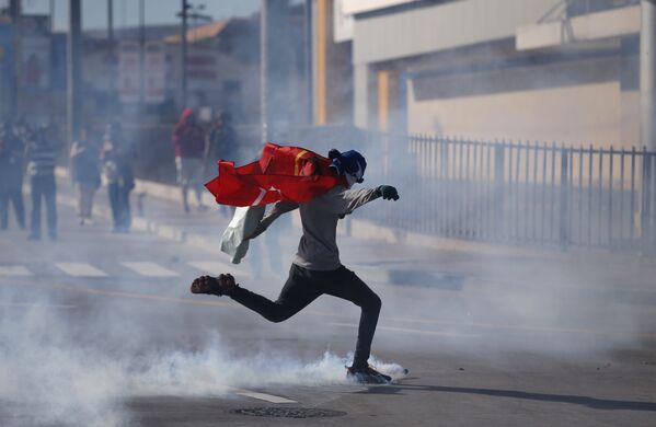 Manifestante dá pontapé em uma lata de gás enquanto a polícia impede apoiadores da oposição de se aproximarem do Estádio Nacional, onde decorre a posse do presidente hondurenho recém-eleito, Juan Orlando Hernandez, em Honduras - Sputnik Brasil