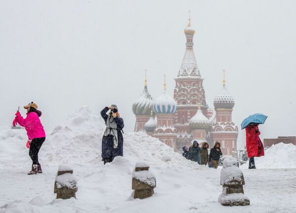 Turistas tiram fotos da Catedral de São Basílio em plena neve, na Praça Vermelha, em Moscou - Sputnik Brasil