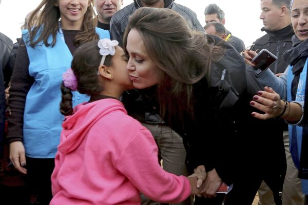 Enviada especial das Nações Unidas, a atriz Angelina Jolie, beija uma criança síria durante sua visita ao campo de refugiados Zaatari, na Jordânia - Sputnik Brasil