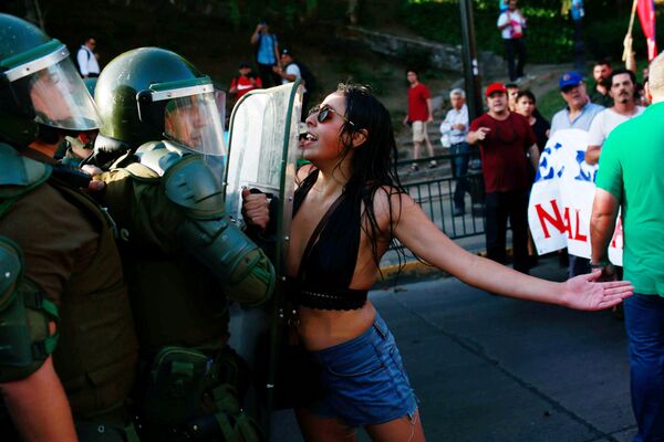 Manifestante confronta policiais durante uma ação popular em apoio à nacionalização das reservas de lítio do país, em Santiago, no Chile - Sputnik Brasil