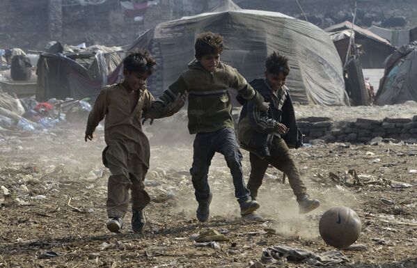 Crianças paquistanesas jogam futebol em uma favela no Paquistão - Sputnik Brasil