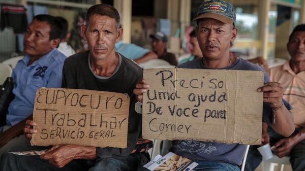 Migrantes venezuelanos seguram de cartazes à procura de trabalho na cidade brasileira de Boa Vista, estado de Roraima, outubro de 2017. - Sputnik Brasil