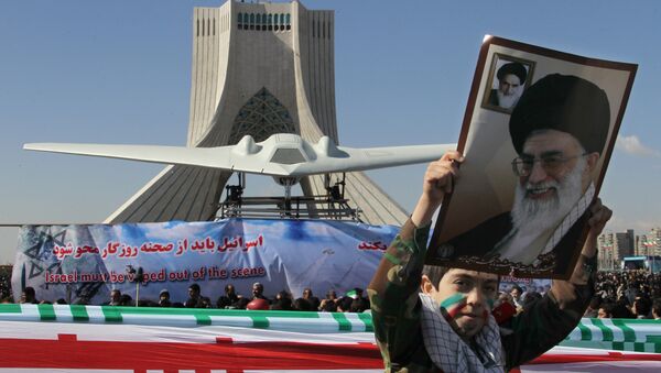 Menino mostra um cartaz do líder supremo do Irã, aiatolá Ali khamenei, enquanto passa perto do drone estadunidense RQ-170 Sentinel - Sputnik Brasil