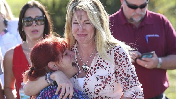 Mulheres choram após tiroteio em escola na Flórida. - Sputnik Brasil