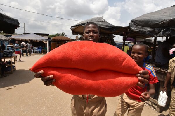 Crianças com almofada em forma de lábios com batom vermelho no Dia dos Namorados, na Costa do Marfim - Sputnik Brasil