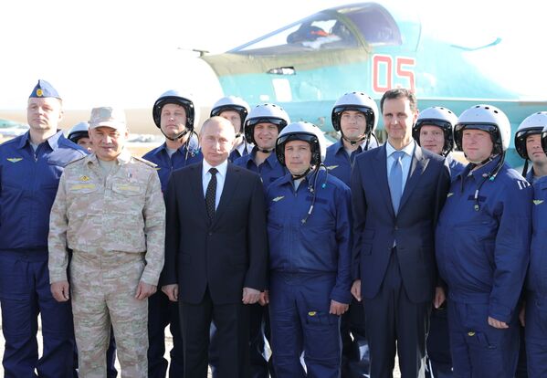 Vladimir Putin, o presidente sírio Bashar Assad e o ministro da Defesa russo Sergei Shoigu, fotografados junto a militares russos durante uma visita à base russa de Hmeymim, em 11 de dezembro de 2017 - Sputnik Brasil