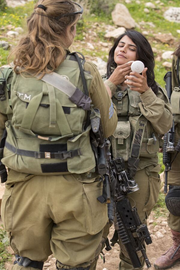 Soldadas israelenses do batalhão misto Lions of the Jordan (Leões da Jordânia) limpam seu rosto após participarem do treinamento final antes de receber seu posto - Sputnik Brasil