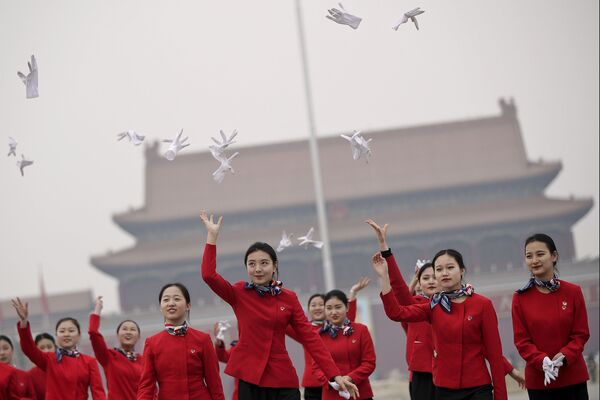 Moças da equipe de hospitalidade atiram as luvas durante o Congresso Nacional do Povo, na Praça Tiananmen em Pequim, China - Sputnik Brasil