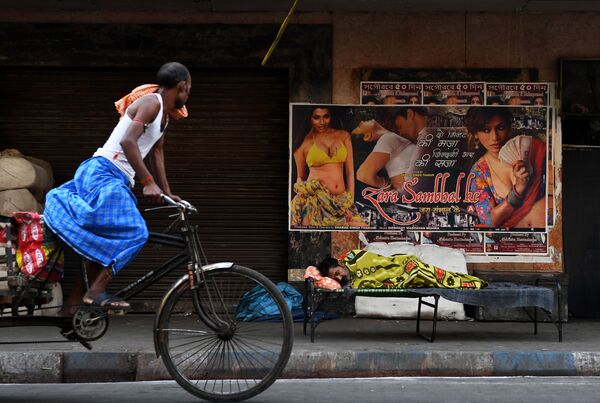 Ciclista hindu passa por homem sem teto, Kolkata, Índia - Sputnik Brasil