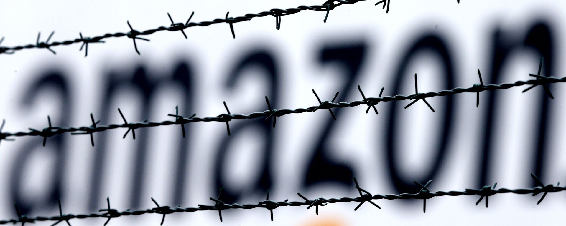 Logotipo da Amazon é visto atrás de uma cerca, em um centro logístico da empresa, em Rheinberg, na Alemanha, em 19 de fevereiro de 2013 (foto de arquivo) - Sputnik Brasil, 1920, 04.08.2022