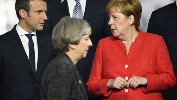 Primeira ministra britânica, Theresa May (centro), passa em frente da chanceler alemã, Angela Merkel (direita), e de Emmanuel Macron (esquerda), presidente da França. - Sputnik Brasil