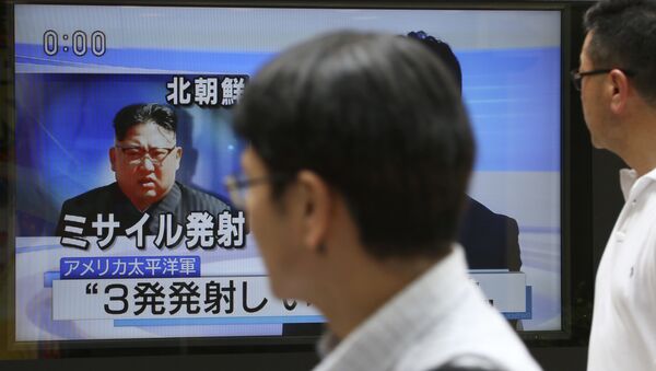 Passers-by watch a TV news program showing image of North Korean leader Kim Jong Un, in Tokyo, Saturday, Aug. 26, 2017 - Sputnik Brasil