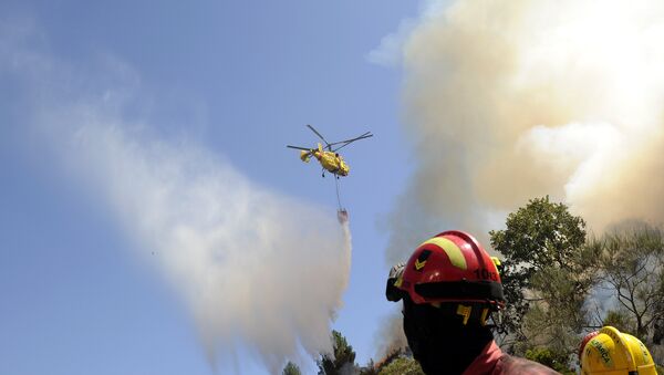 Bombeiros observam helicóptero Kamov jogando água sobre incêndio florestal em Penoita, perto de Vouzela, centro de Portugal, 23 de agosto de 2013 - Sputnik Brasil