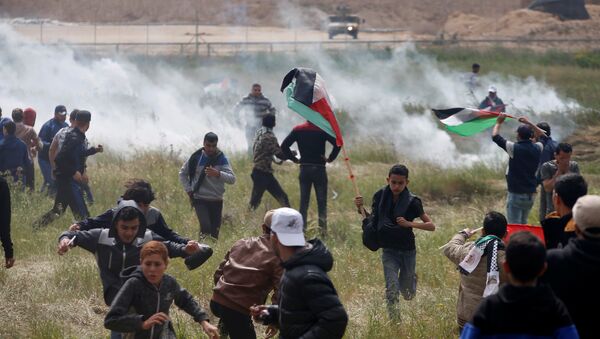 Palestinos correm de gás lacrimogênio atirado por tropas israelenses durantes protesto na Faixa de Gaza. - Sputnik Brasil