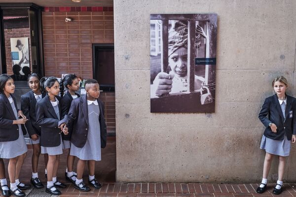 Alunas sul-africanas perto de um cartaz que retrata a ex-mulher de Nelson Mandela - Sputnik Brasil