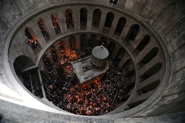 Crentes seguram velas ao tomarem parte da cerimônia do Fogo Sagrado na Basílica do Santo Sepulcro, em Jerusalém - Sputnik Brasil
