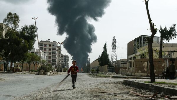 A child runs along a street in front of clouds of smoke billowing following a reported air strike on Douma, the main town of Syria's rebel enclave of Eastern Ghouta - Sputnik Brasil