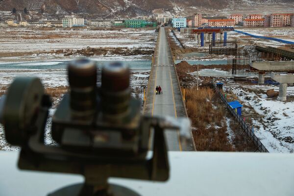 Mulher fotografada da parte chinesa da fronteira é vista do ponto de observação usado pelos turistas para dar uma olhada à Coreia do Norte - Sputnik Brasil