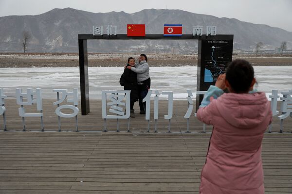 Pessoas se fotografam perto da fronteira com a Coreia do Norte, na China - Sputnik Brasil
