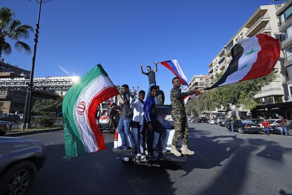 Manifestastes contra os ataques da coalizão internacional na Síria agitando bandeiras da Síria, Irã e Rússia - Sputnik Brasil