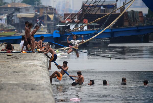 Crianças se banham em água poluída da baía de Manila durante o calor extremo nas Filipinas - Sputnik Brasil