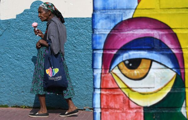 Mulher come sorvete caminhando por uma das ruas da capital hondurenha, Tegucigalpa - Sputnik Brasil