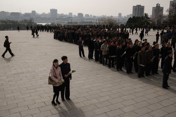 Pessoas depõem flores nos monumentos dos líderes norte-coreanos Kim Il-sung e Kim Jong-il, Pyongyang, 15 de abril de 2018 - Sputnik Brasil