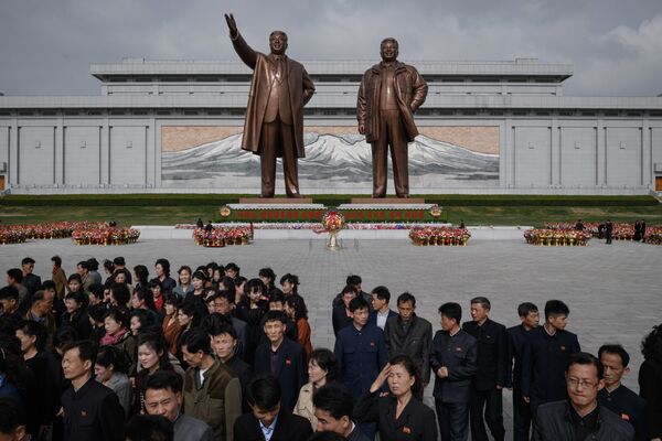 Pessoas perto dos monumentos dos líderes norte-coreanos Kim Il-sung e Kim Jong-il, Pyongyang, 15 de abril de 2018 - Sputnik Brasil