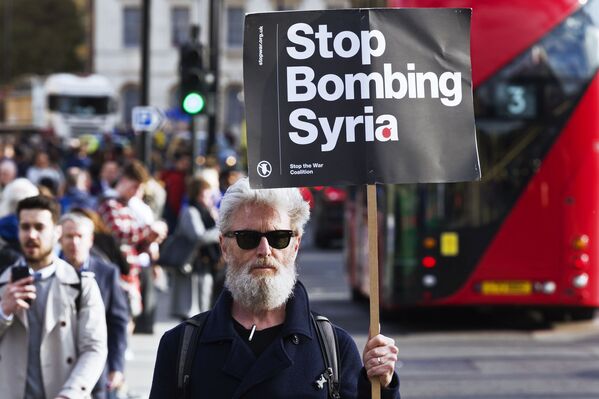 Homem segurando cartaz apelando para não bombardear a Síria durante um protesto contra os ataques à Síria em Londres. - Sputnik Brasil