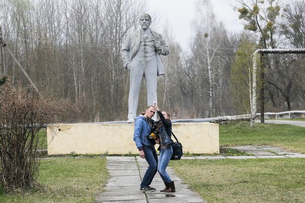 Jornalistas tirando selfies perto do monumento de Vladimir Lenin (líder fundador da União das Repúblicas Socialistas Soviéticas) em Chernobyl - Sputnik Brasil