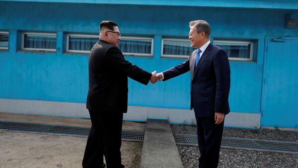 Líderes da Coreia do Norte, Kim Jong-un, e da Coreia do Sul, Moon Jae-in, apertam as mãos durante encontro na localidade de Panmunjom, na zona desmilitarizada que separa os dois países - Sputnik Brasil