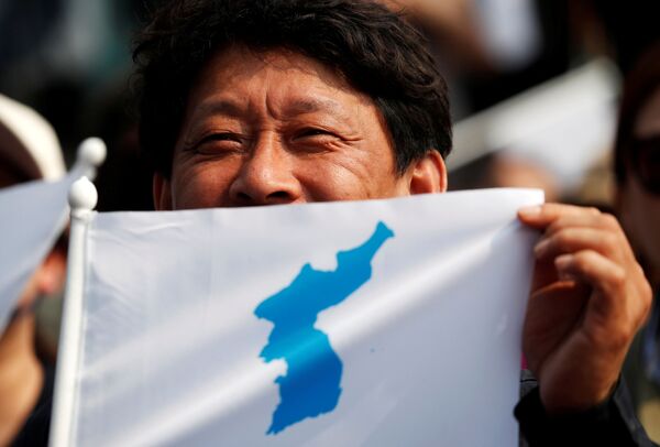 Homem mostra a bandeira do Império Coreano na véspera da cerimônia do encontro dos líderes da Coreia do Norte, Kim Jong-un, e da Coreia do Sul, Moon Jae-in - Sputnik Brasil