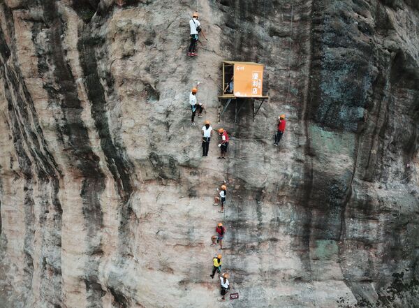 Pessoas praticam escalada na cidade de Pingjiang, na China - Sputnik Brasil