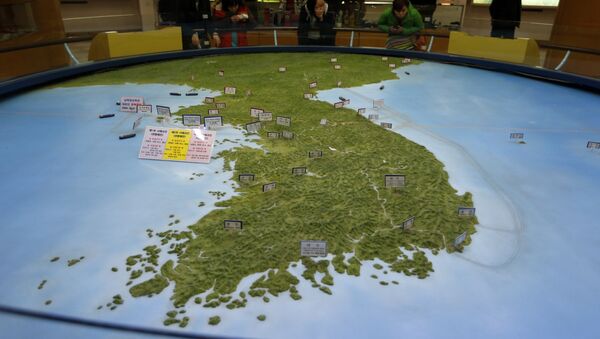 Visitantes olhando para o mapa da península coreana no observatório da reunificação em Paju, Coreia do Sul - Sputnik Brasil