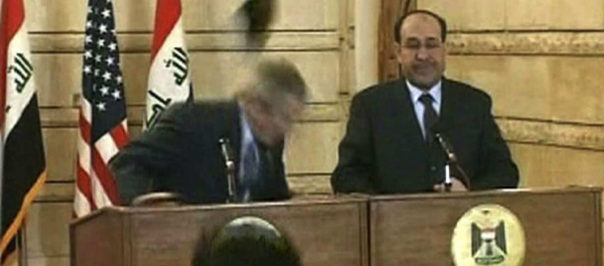 In this image from APTN video, a man throws a shoe at President George W. Bush during a news conference with Iraq Prime Minister Nouri al-Maliki on Sunday, Dec. 14, 2008, in Baghdad. The man threw two shoes at Bush, one after another. Bush ducked both throws, and neither man was hit. - Sputnik Brasil, 1920, 01.05.2018