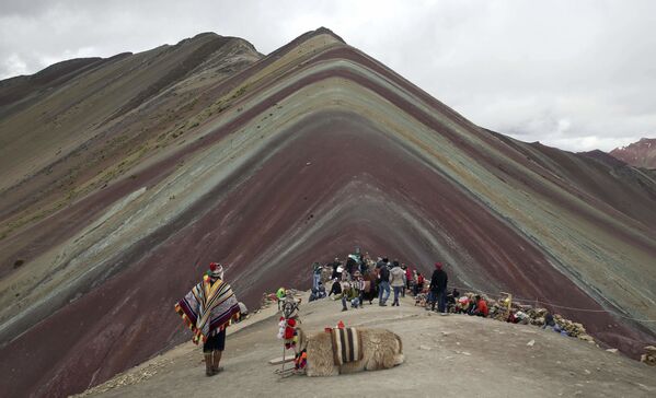 Morador indígena dos Andes com lama e turistas em frente da montanha Vinicunca, no Peru - Sputnik Brasil