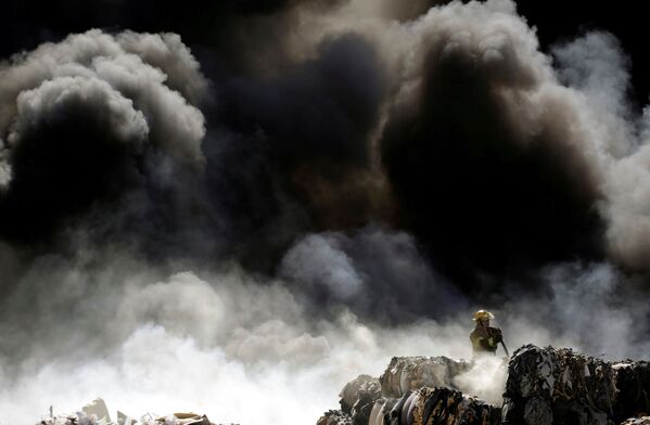 Bombeiro combate o fogo no centro de reciclagem de pneus vencidos, no México - Sputnik Brasil