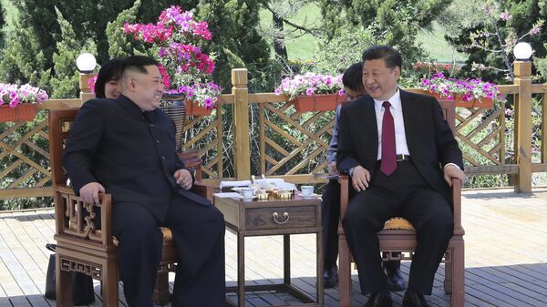 Presidente chinês, Xi Jinping (à direita), falando com o líder norte-coreano, Kim Jong-un (à esquerda) em Dalian, China - Sputnik Brasil