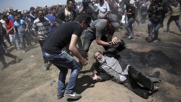 Um idoso palestino cai no chão depois de ser baleado por tropas israelenses durante um protesto na fronteira da Faixa de Gaza com Israel, a leste de Khan Younis. - Sputnik Brasil