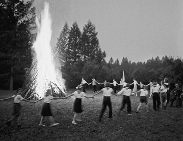 Pioneiros fazem dança popular de roda junto à fogueira em um campo de férias, em 1961 - Sputnik Brasil