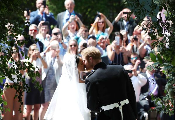 O Príncipe Harry e a sua noiva, Meghan Markle, trocam o primeiro beijo como marido e mulher, após a cerimônia, em frente à Capela de São Jorge, em Windsor - Sputnik Brasil