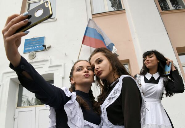 Finalistas escolares russas tiram selfie durante a festa tradicional do Último Toque, que celebra o fim do ano letivo - Sputnik Brasil