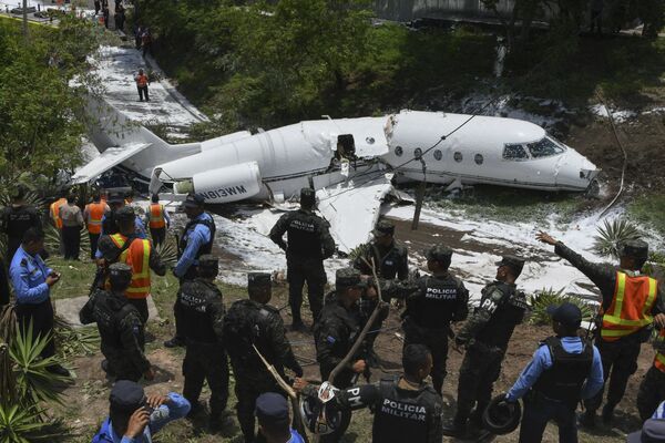 Polícia e equipes de resgate trabalham no Aeroporto Internacional de Toncontín, onde caiu na pista um avião privado norte-americano, Honduras - Sputnik Brasil